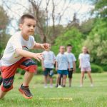 A group of children actively playing with hula hoops on a bright summer day in the park.